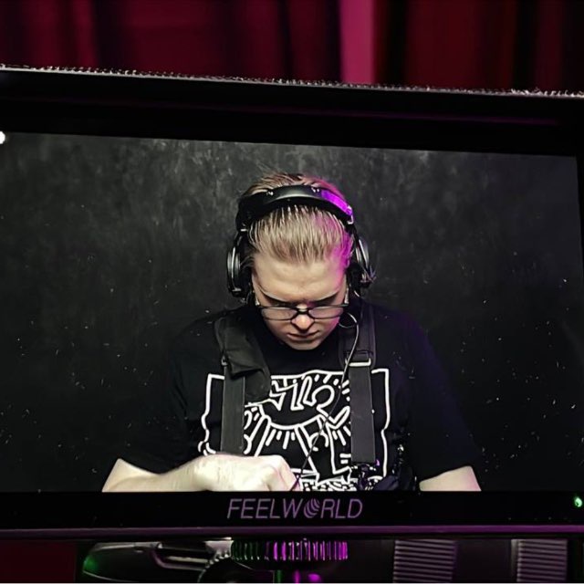 Andrey wearing headphones and working behind a production monitor